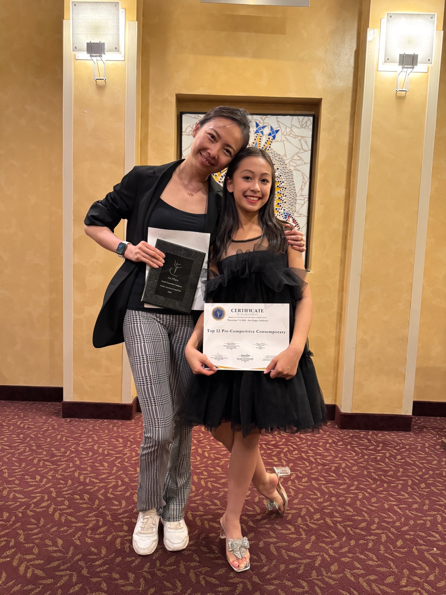 Mi Deng with student celebrating a competition award